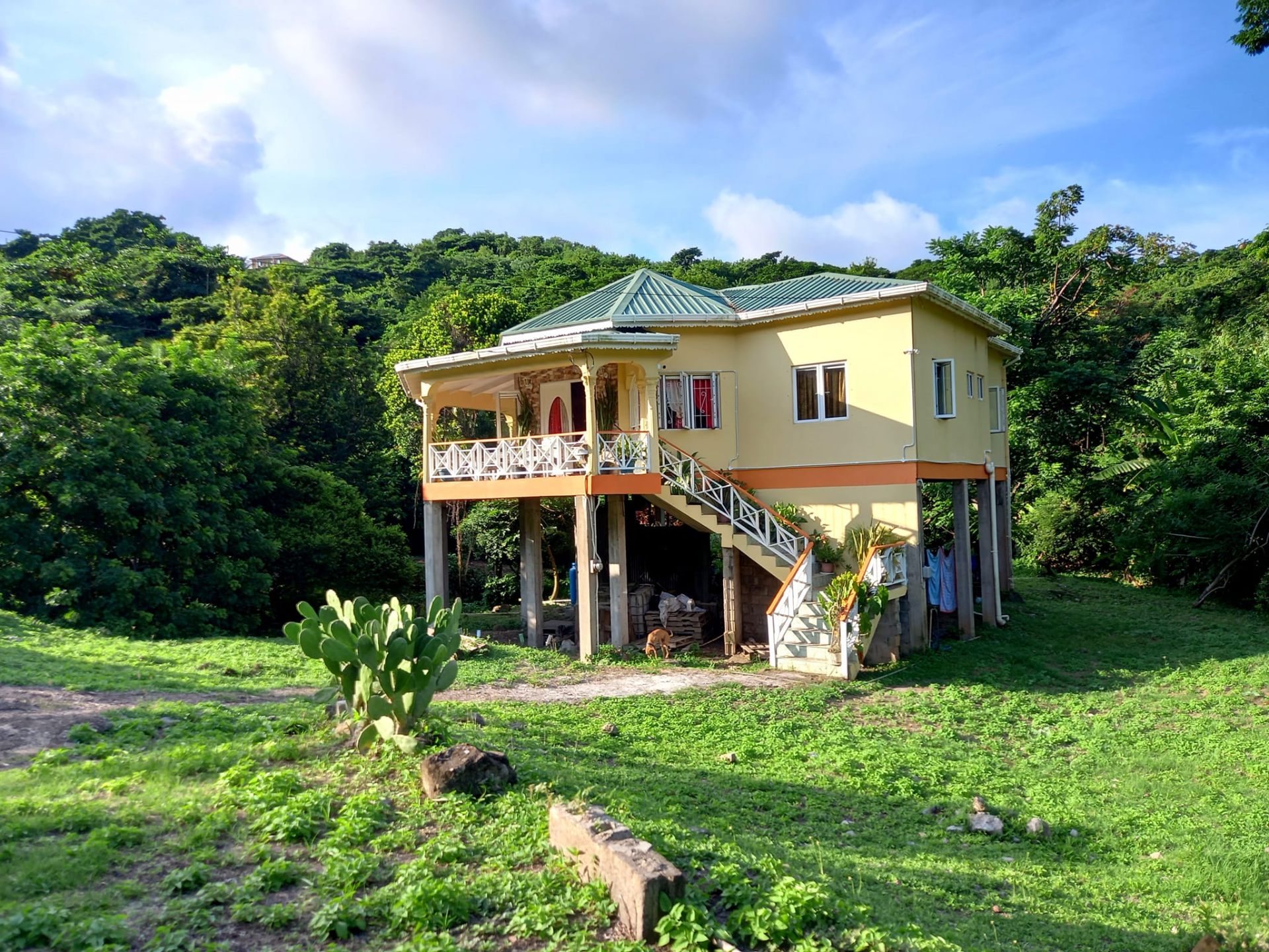 Front view of the elevated yellow home with veranda